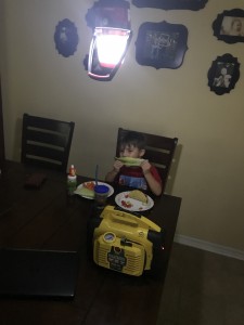 My oldest son eating tacos by lantern light.